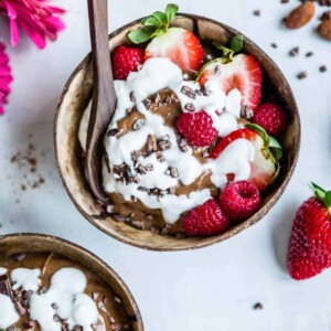 Spoon in a chocolate smoothie bowl with berries.