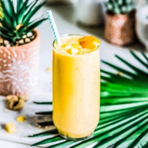 Bright yellow mango smoothie in a glass.
