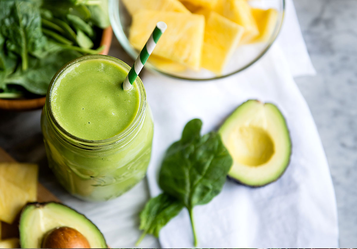 Green smoothie on table with avocado from the 21-day cleanse detox.