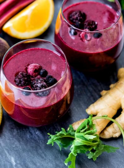 Two glasses full of anti-inflammatory smoothie topped with berries.