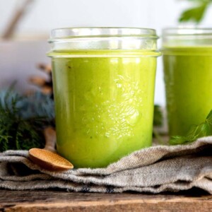 Two glass jars of green blended vegetable soup.