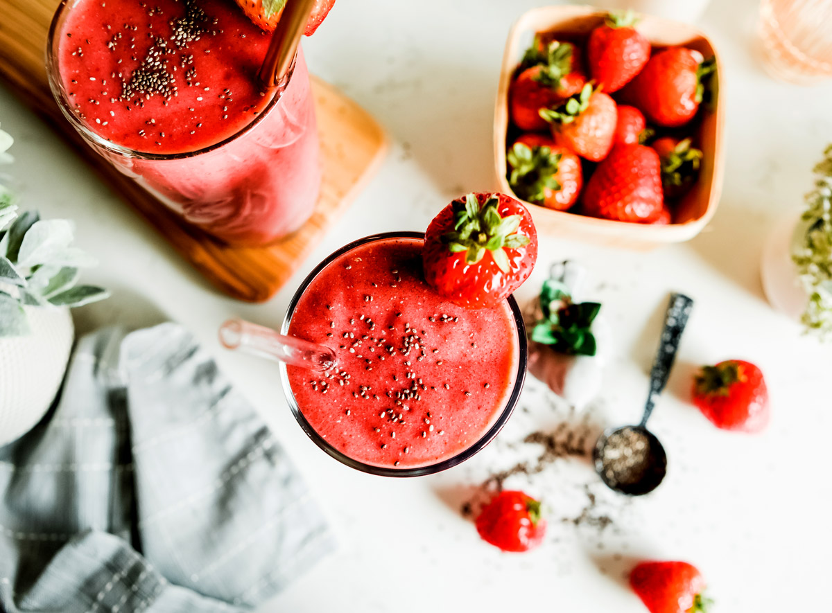 Looking down at a glass of strawberry banana smoothie with chia seeds on top.