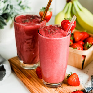 Strawberry banana smoothie recipe in pint glass with straw.