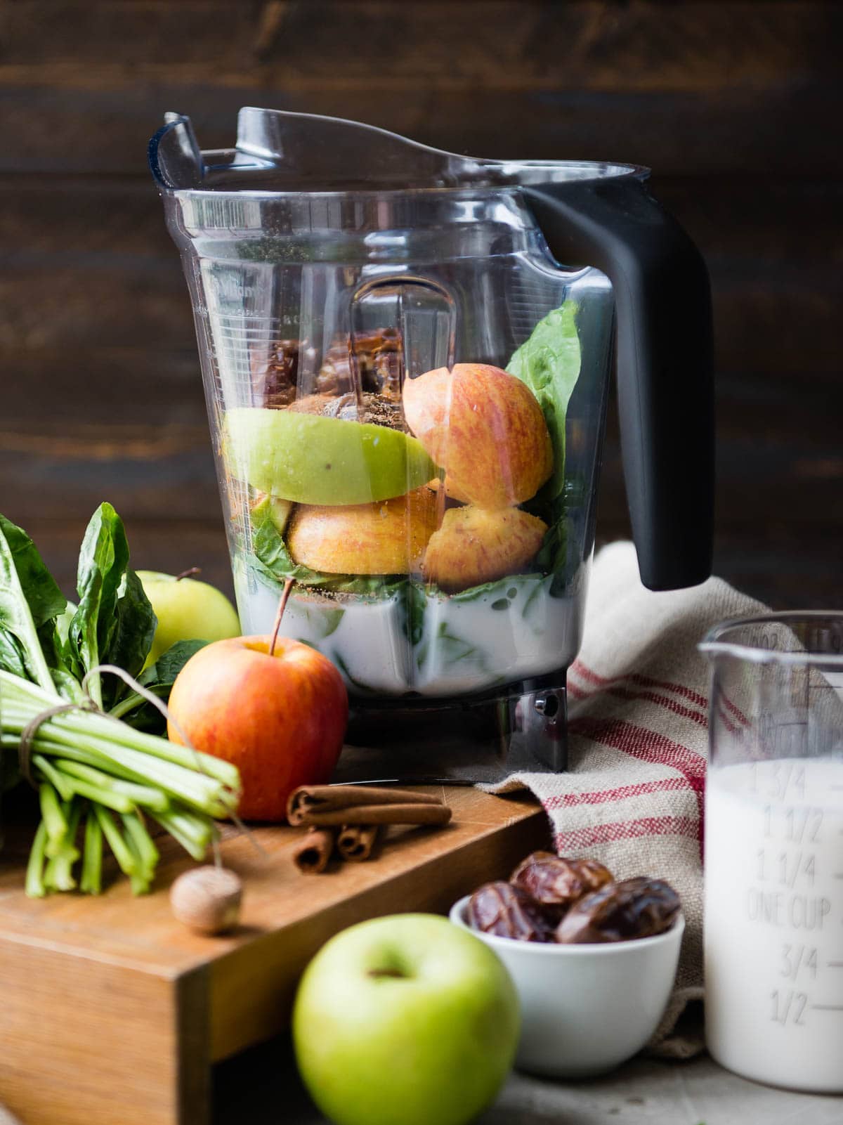 Vitamix blender container full of raw ingredients for a green smoothie.