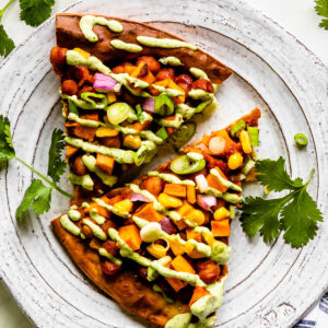 Two slices of barbeque vegetarian pizza on a plate.
