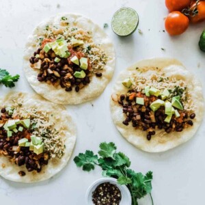 Three bean and rice burritos on a white countertop.