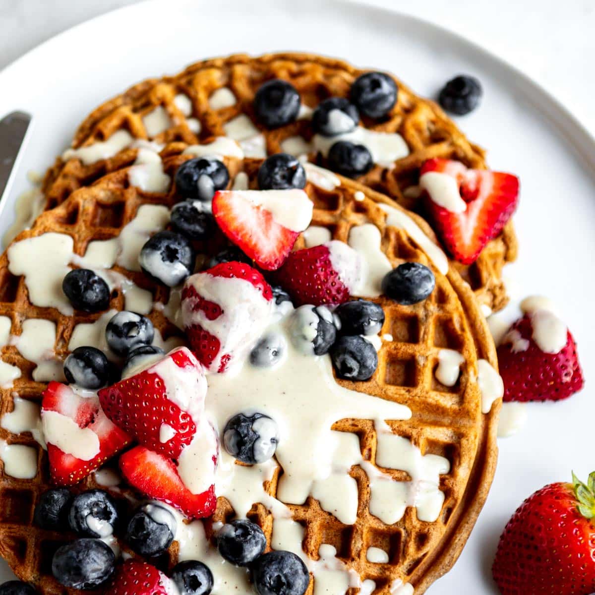 Best vegan waffles topped with cream and fresh berries.