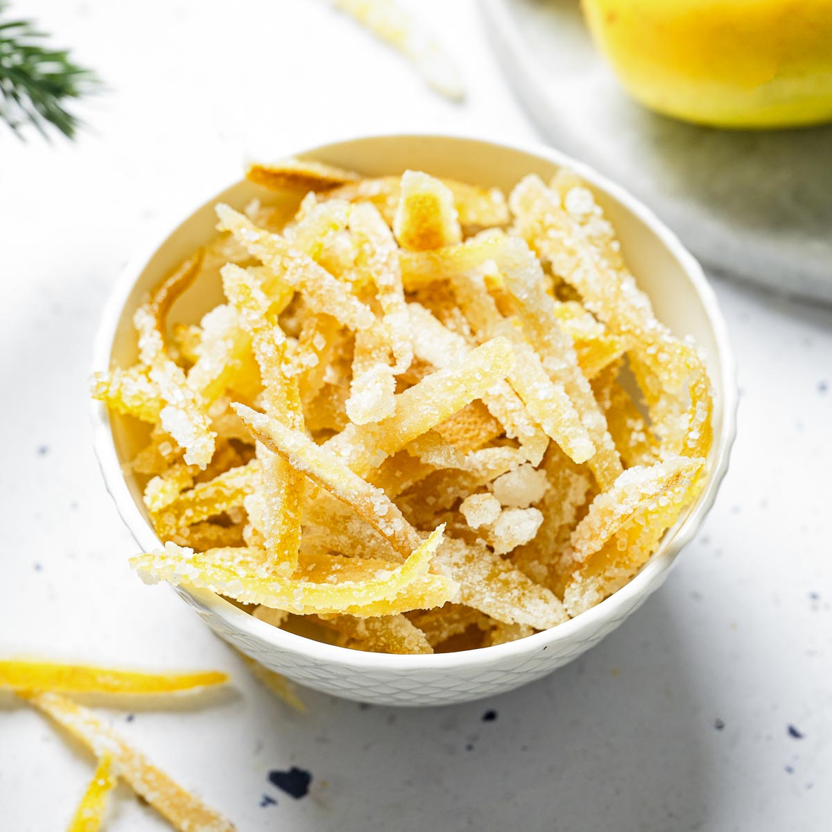 White bowl containing sugared candied lemon peels.