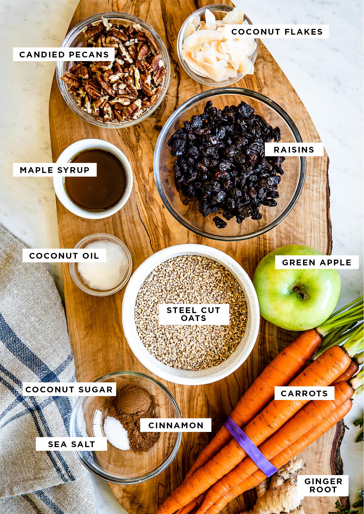 Ingredients for carrot cake oatmeal including coconut flakes, candied pecans, maple syrup, and raisins.