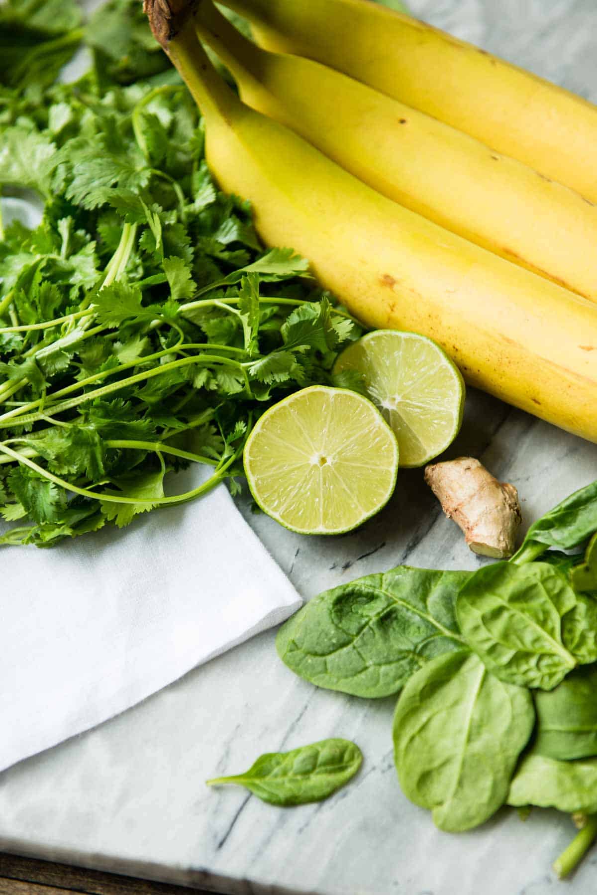 Ingredients for a citrus cilantro smoothie including banana, ginger, and lime.