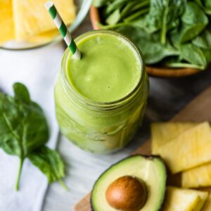 Green and white straw in a green smoothie.