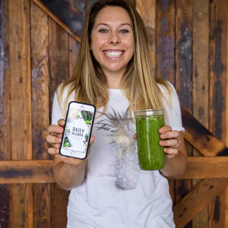 Jen holding a smoothie and a phone that reads \"Daily Blends.\"