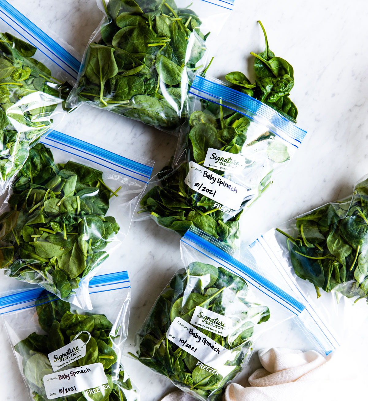 Several plastic bags of baby spinach.