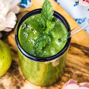 Bright green smoothie in a tall glass.