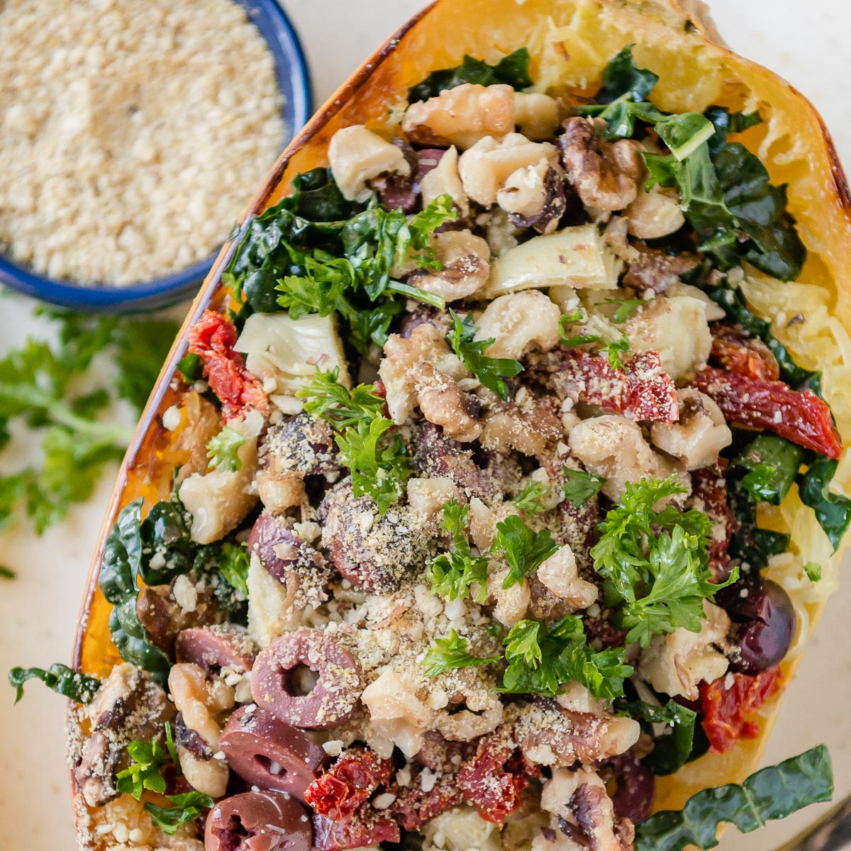 grain free diet meal with spaghetti squash topped with kale, walnuts, sun-dried tomatoes and vegan cheese.