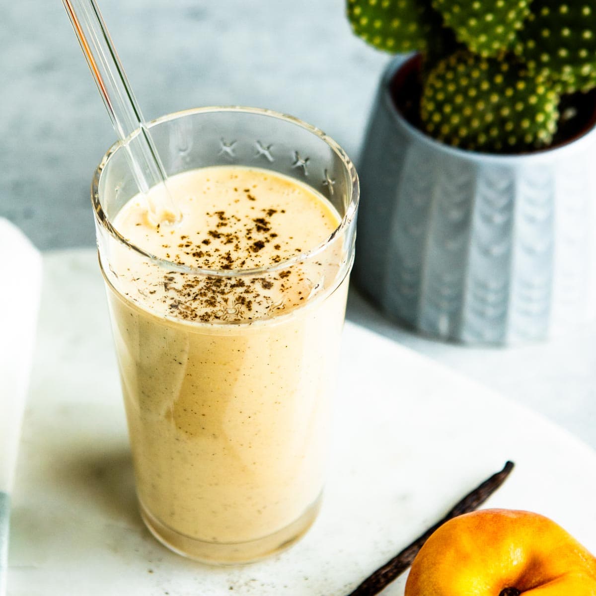 homemade protein shake in glass with glass straw.