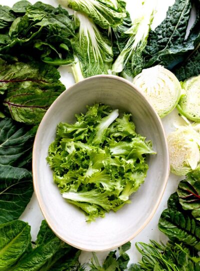 Bowl with romaine surrounded by leafy greens.