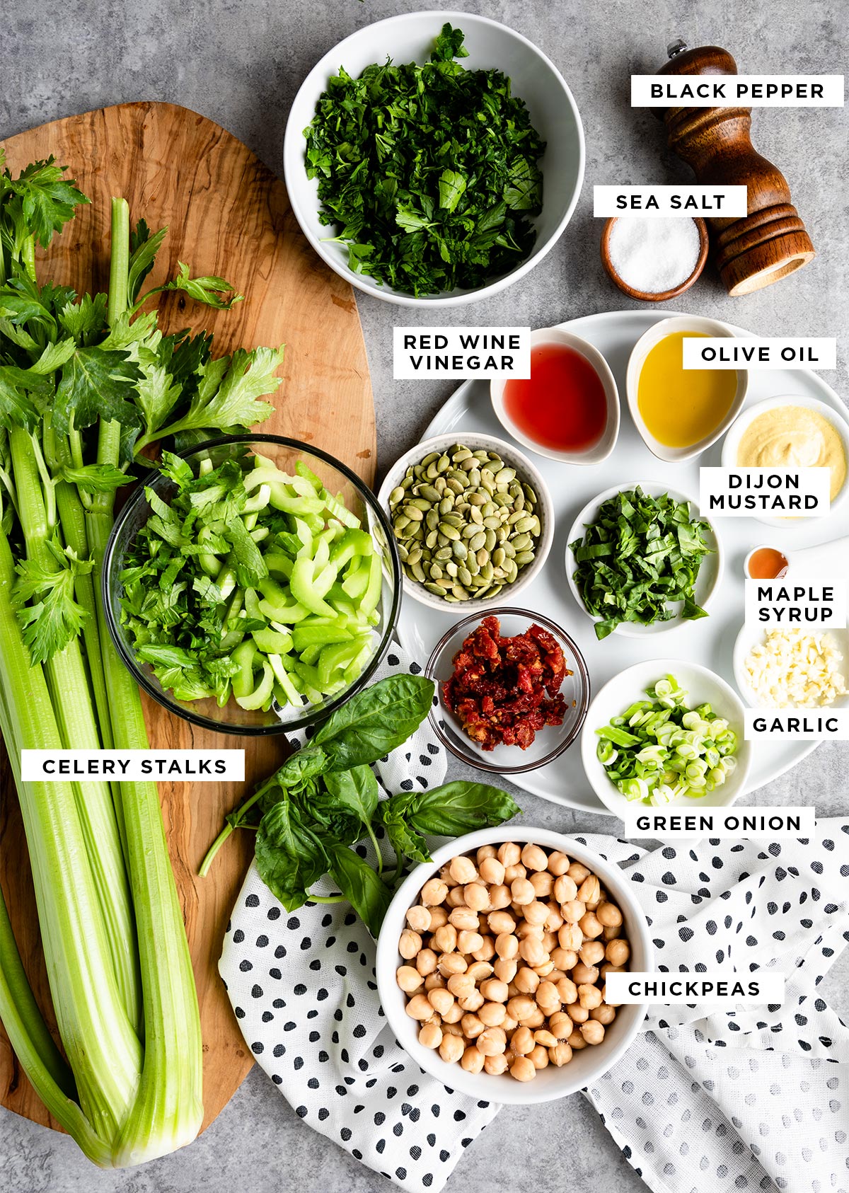 Marinated celery salad ingredients including red wine vinegar, olive oil, dijon mustard, maple syrup, and chickpeas.