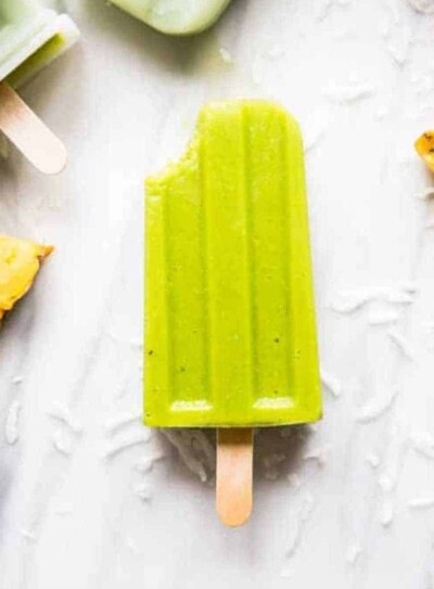 Green smoothie popsicle missing a bite.