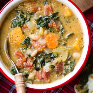 Spoon in a bowl of vegan minestrone soup.