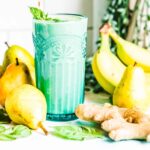 Blue glass of acid reflux smoothie surrounded by fruits and ginger.